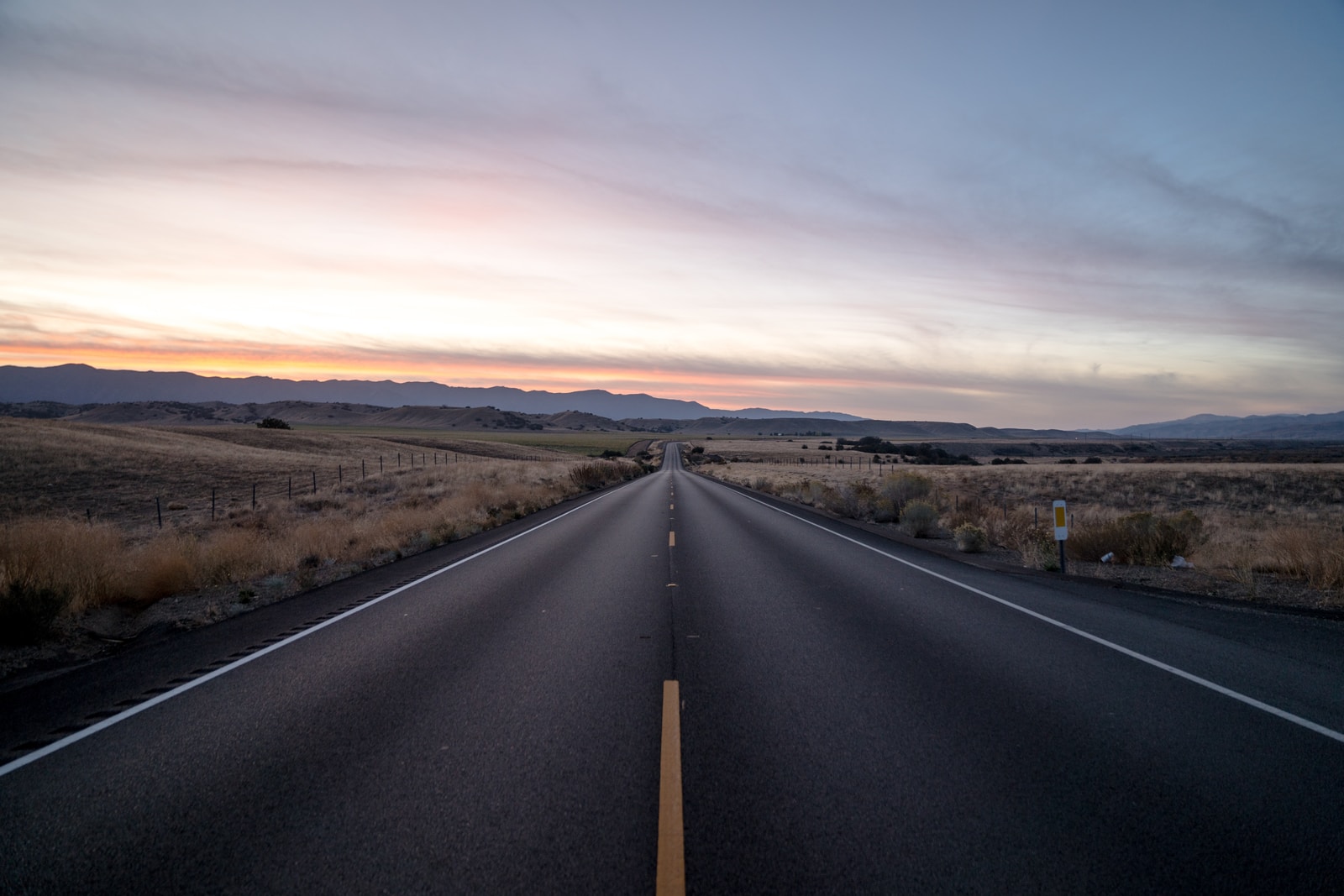 empty black wooden bench beside road